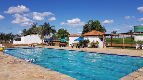 a pool with tables and umbrellas at a resort at Pousada Esperança in Boa Esperança