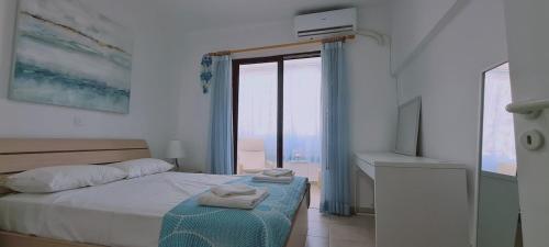 a white bedroom with a bed and a window at STAY EasyDream Maisonette in Paralimni