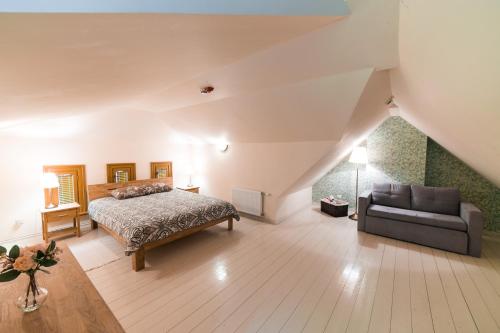 a large bedroom with a bed and a couch at Cottage Dzintars in Jūrmala