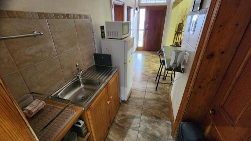 a small kitchen with a sink and a refrigerator at Profcon Resort in Graaff-Reinet