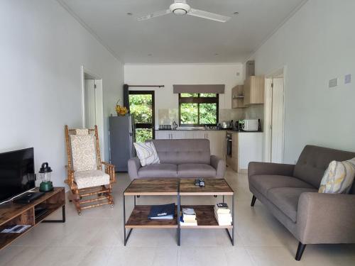 Sala de estar con 2 sofás y mesa de centro en Villa Laure en Grand'Anse Praslin