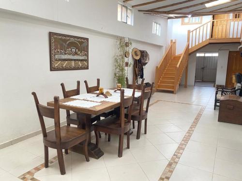 uma sala de jantar com uma mesa de madeira e cadeiras em Hospedaje Casa Lola em Susa