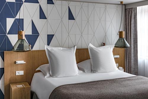 a hotel room with a bed with white pillows at White 1921 Courchevel in Courchevel