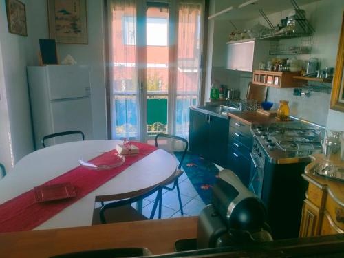 cocina con mesa blanca y nevera blanca en Appartamento formula residence, en Casavecchie