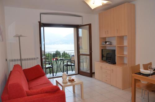 salon z czerwoną kanapą i balkonem w obiekcie Lake Como View Apartement Allegro w mieście Acquaseria