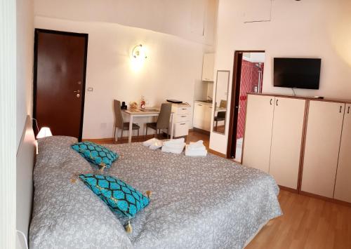 ein Schlafzimmer mit einem Bett mit blauen Kissen darauf in der Unterkunft Da Enzo in Desenzano del Garda
