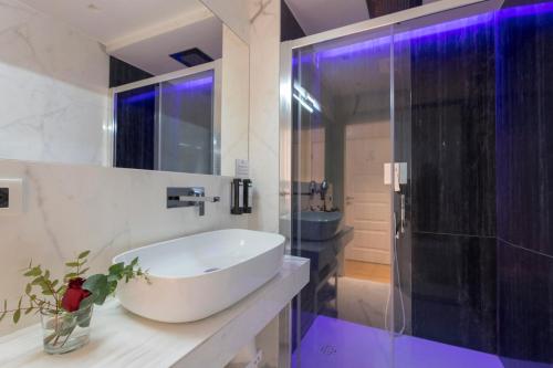 a bathroom with a sink and a shower with purple lights at Argentina Residenza Style Hotel in Rome