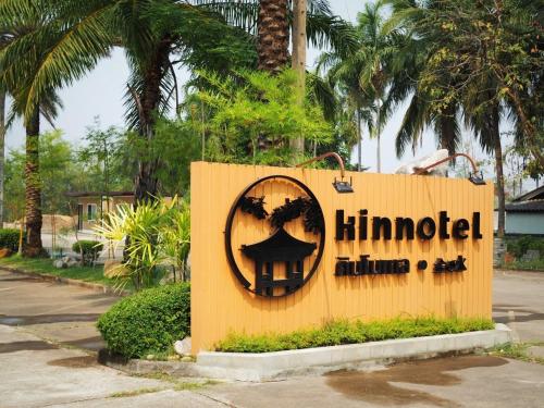 una señal para un hotel himud con palmeras en Kinnotel en Phrae