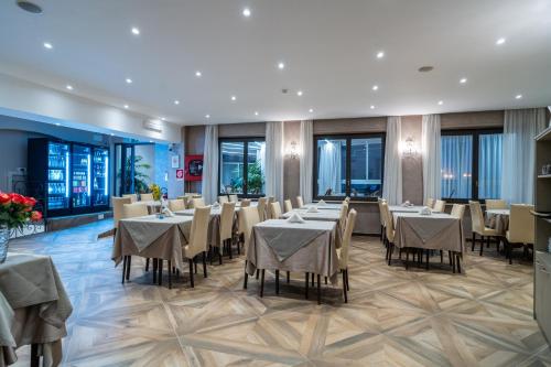 uma sala de jantar com mesas, cadeiras e janelas em Hotel Globo Suite-Correnti hotels em Sanremo