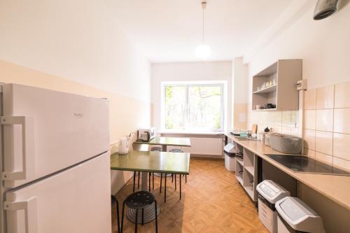 a kitchen with a table and a white refrigerator at Summer hostel Kaija in Jūrmala