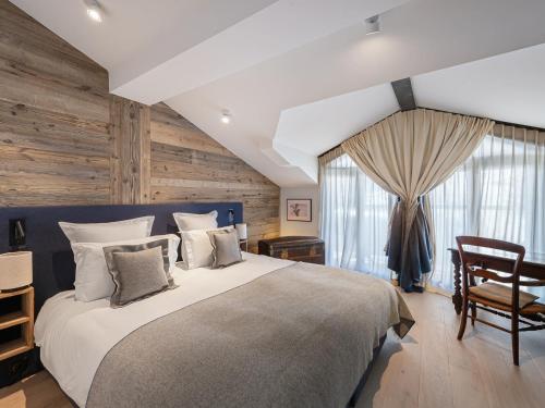 - une chambre avec un grand lit et un mur en bois dans l'établissement Appartement familial neuf à Courchevel près des commerces et pistes - FR-1-562-65, à Courchevel