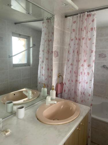 La salle de bains est pourvue d'un grand lavabo rose et d'une baignoire. dans l'établissement Maison de vacances, à Frotey-lès-Vesoul