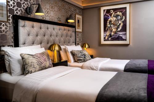 a hotel room with two beds and a painting on the wall at Roxford Lodge Hotel in Dublin