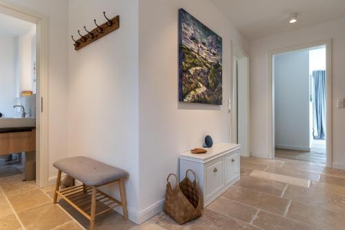 a living room with a chair and a painting on the wall at Reetdachhaus De Hygge Kaat Reetdachhaus De Hygge Kaat in Wittendün