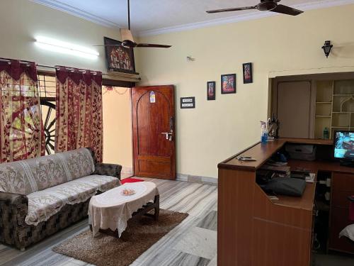 sala de estar con sofá y mesa en The Padmavathi Guest House - Vizag, en Visakhapatnam