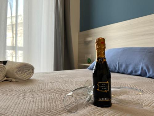 a bottle of champagne sitting on a bed with glasses at B&B Costa degli Dei in Tropea