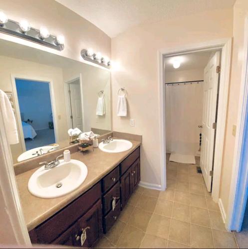 a bathroom with two sinks and a large mirror at Boll Weevil Cottage in Enterprise