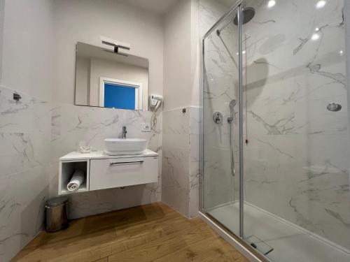 a white bathroom with a sink and a shower at B&B Costa degli Dei in Tropea