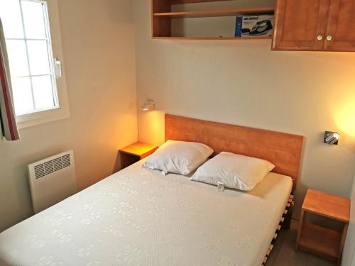 een slaapkamer met een bed met 2 witte kussens bij L Escale - 6 personnes in Saint-Hilaire-de-Talmont