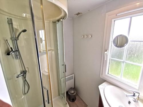 een badkamer met een douche, een wastafel en een raam bij L Escale - 6 personnes in Saint-Hilaire-de-Talmont