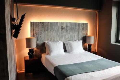 阿姆斯特丹的住宿－Rooms25，一间卧室配有一张带两盏灯的大型白色床。