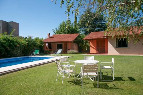 a table and chairs in a yard next to a pool at Casa luminosa con pileta ¡ideal para descansar! in Ciudad Lujan de Cuyo