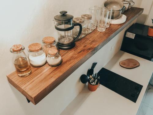 a wooden shelf with jars on top of a kitchen counter at Ayampe Lofts in Ayampe