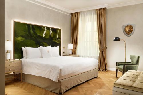 a hotel room with a large bed and a chair at Luxury Apartments by Palazzo Portinari Salviati in Florence