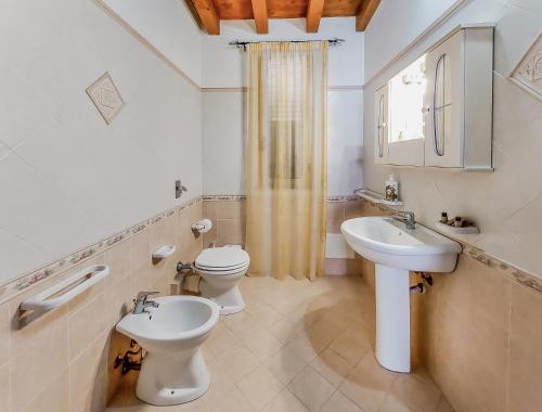 łazienka z 2 toaletami i umywalką w obiekcie Casetta Orchidea A pochi passi dal Centro w mieście Lampedusa