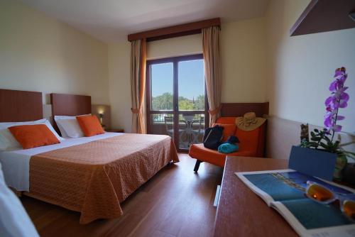 a hotel room with two beds and a balcony at VALTUR OTIUM RESORT in Villapiana