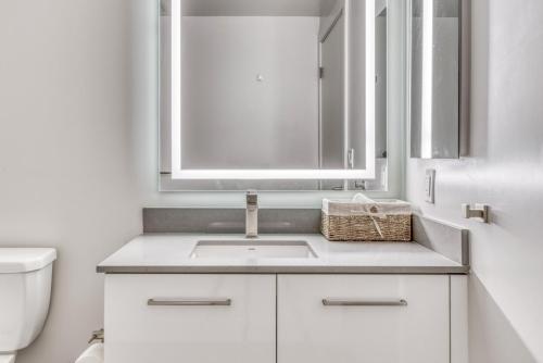 uma casa de banho branca com um lavatório e um espelho em Oakland 1BR w AC WD Sky Deck next to BART SFO-527 em Oakland