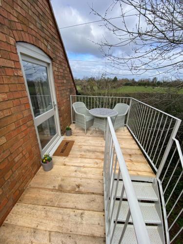 a wooden deck with a table and chairs on a building at The Upside Down House at The Mercers in Worcester