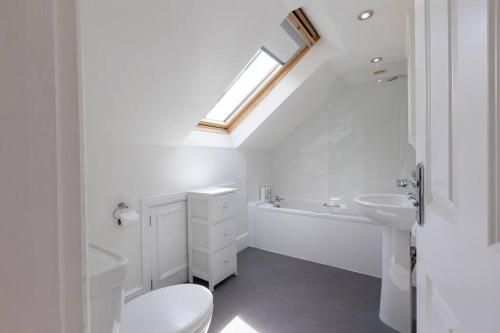 a white bathroom with a toilet and a sink at The Lemon Grove, Leyburn in Leyburn