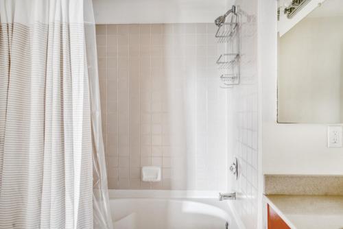 a bathroom with a tub and a white shower curtain at San Jose 1BR w Gym Pool WD nr Caltrain SFO-902 in San Jose