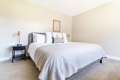 a white bedroom with a large bed with white pillows at Foster City 2BR w Gym Pool WD nr highways SFO-566 in Foster City