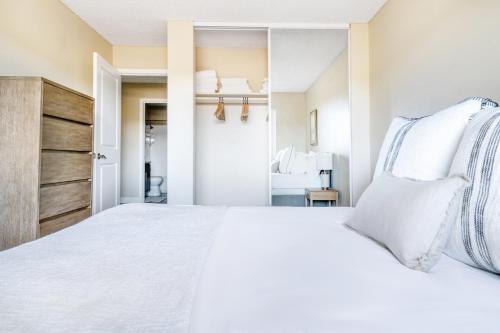 a bedroom with a large white bed with a mirror at Foster City 2BR w Gym Pool WD nr highways SFO-566 in Foster City