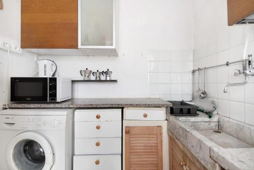 a kitchen with a washing machine and a microwave at Rezzano 12 in Bonassola