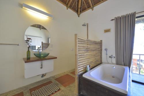 a bathroom with a large tub and a mirror at Hangin Kite Resort in Boracay