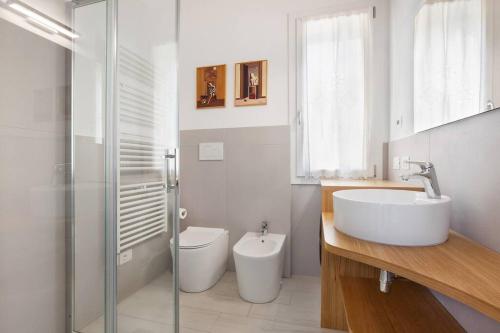 a white bathroom with a sink and a toilet at Villa Malù - APT Luisa Piscina e vista lago in Torri del Benaco
