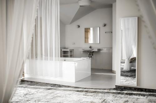 a white bathroom with a tub and a mirror at Maria Szczyrk in Szczyrk