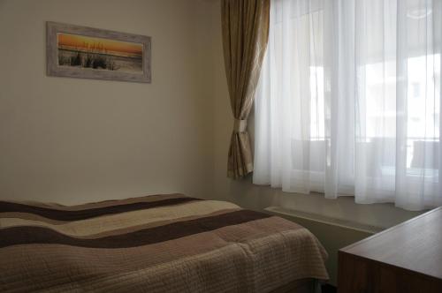A bed or beds in a room at Galerius Happy Family Apartman Siófok