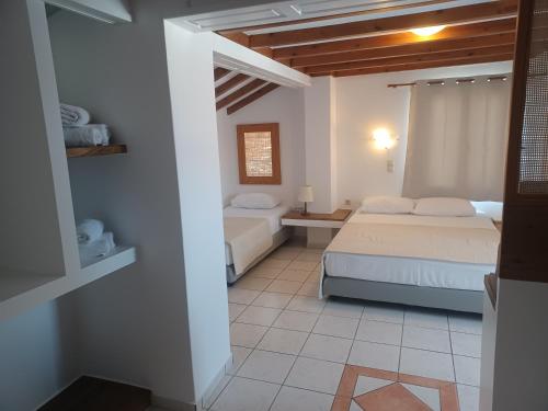 1 dormitorio con 2 camas y ventana. en Villa Margarita en Spétses