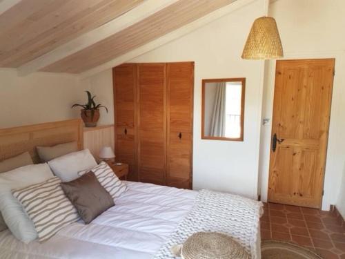 ein Schlafzimmer mit einem weißen Bett und einer Holzdecke in der Unterkunft Maison Andalouse avec piscine in El Almendral