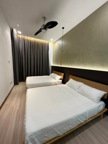 a bedroom with two beds and a ceiling fan at Melaka Duplex Penthouse 3 Bedroom The Wave Residence 9pax in Melaka