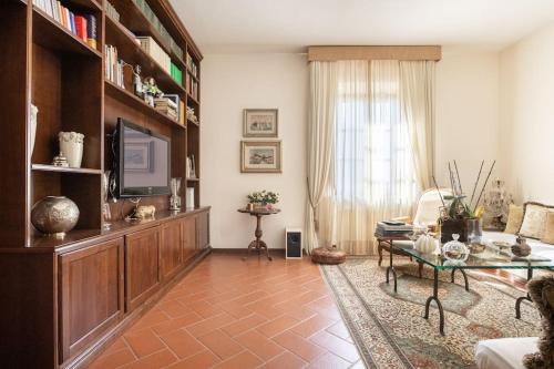 sala de estar con sofá, mesa y TV en Il Poggiolino - Tuscan villa located in Chianti's hills, en Badia A Passignano
