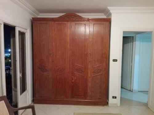 ein großer Holzschrank in einem Zimmer mit einer Tür in der Unterkunft 13 خلف عمارات العبور مصر الجديده in Kairo