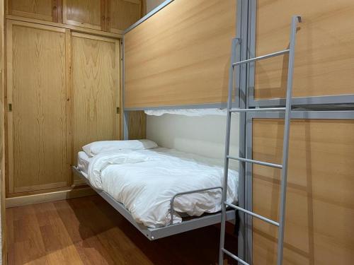 Un dormitorio con una litera y una escalera. en EUROPA HOUSE - Parking GRATIS, en Sierra Nevada