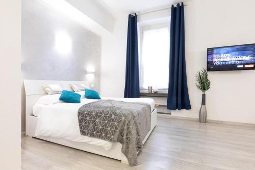 Dormitorio blanco con cama con almohadas azules en Trastevere Silver King JacuzziSuite -TopCollection, en Roma