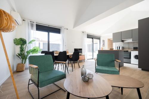 un salon avec des chaises vertes et une table dans l'établissement Complexe Les Maisons du Parc - 4 maisons standing - Clim Parking 30 pers, à Marseille