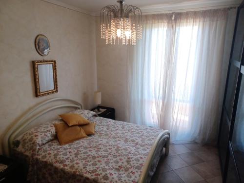 a bedroom with a bed and a chandelier at CASAVACANZE MEVANIA in Bevagna